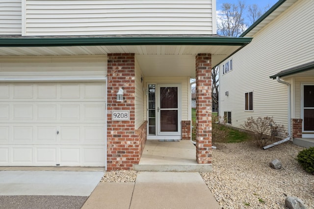 property entrance with brick siding, a porch, and an attached garage