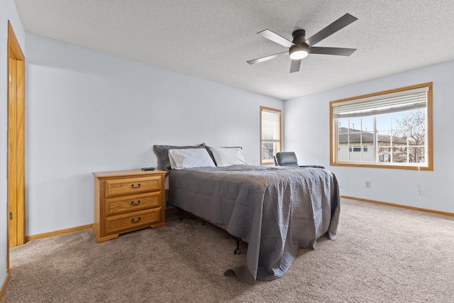 bedroom featuring a textured ceiling, a ceiling fan, carpet floors, and baseboards