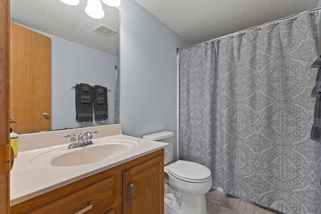 bathroom featuring a textured ceiling, visible vents, toilet, vanity, and tile patterned flooring