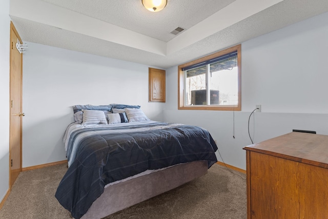 bedroom with carpet flooring, a textured ceiling, visible vents, and baseboards