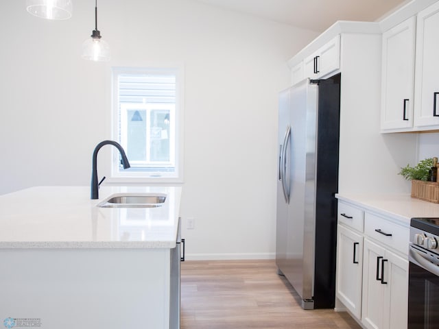 kitchen with light wood-style floors, white cabinetry, a sink, hanging light fixtures, and stainless steel appliances