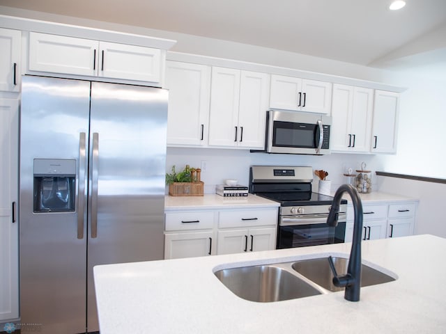 kitchen with recessed lighting, light countertops, white cabinets, a sink, and stainless steel appliances