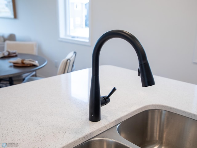 room details with light stone counters and a sink