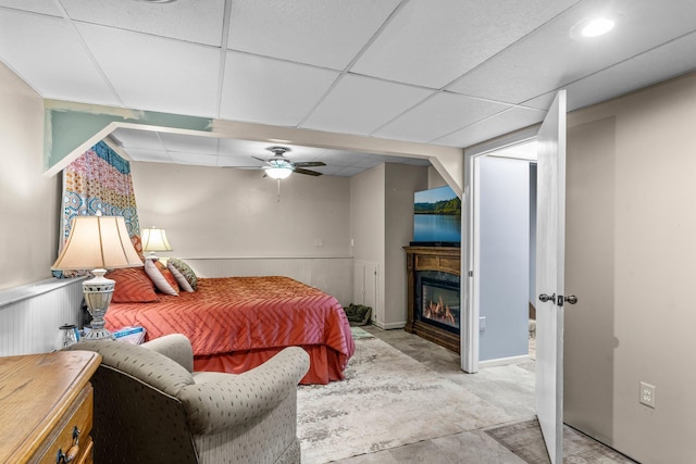 13229 Fremont Ave, Zimmerman, MN 55398 - bedroom featuring a drop ceiling, a ceiling fan, a glass covered fireplace, and a wainscoted wall