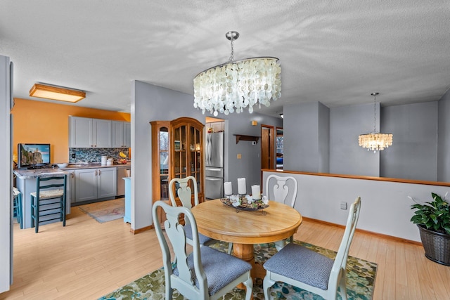 13229 Fremont Ave, Zimmerman, MN 55398 - dining space featuring a chandelier, light wood finished floors, and a textured ceiling