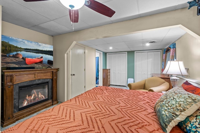13229 Fremont Ave, Zimmerman, MN 55398 - bedroom featuring a paneled ceiling, multiple closets, a glass covered fireplace, and ceiling fan
