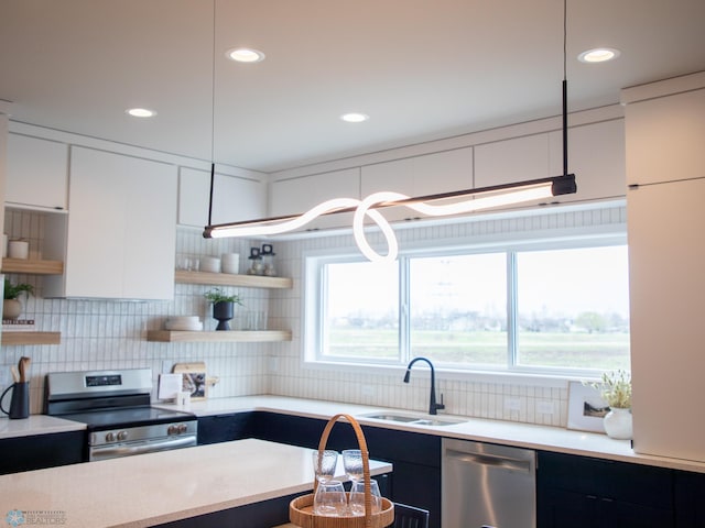 kitchen with open shelves, modern cabinets, light countertops, a sink, and appliances with stainless steel finishes