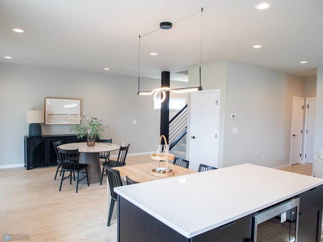 kitchen featuring light wood-style flooring, recessed lighting, and beverage cooler