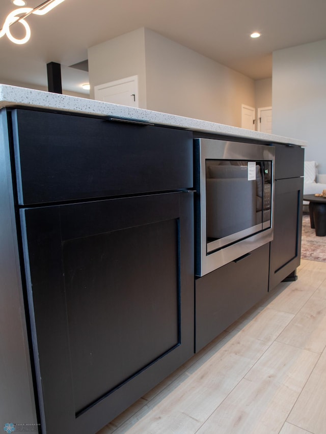 kitchen featuring light wood-type flooring and built in microwave