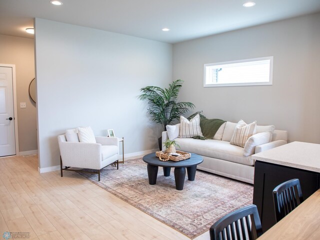 living room featuring recessed lighting, baseboards, and light wood-style flooring