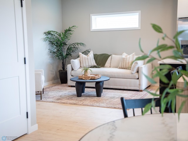 living area with baseboards and wood finished floors