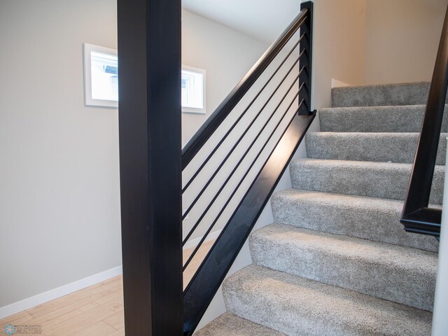 stairway with baseboards and wood finished floors