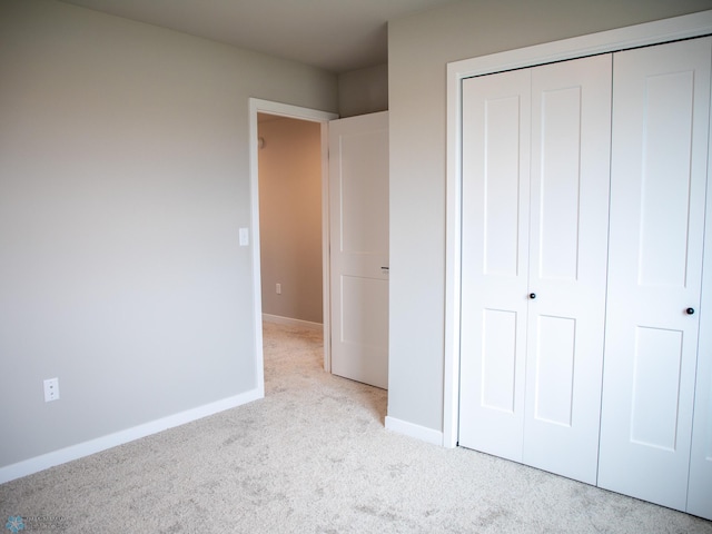 unfurnished bedroom featuring a closet, carpet, and baseboards