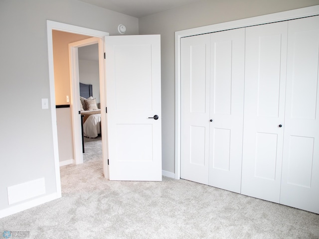 unfurnished bedroom featuring carpet flooring, baseboards, and a closet