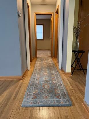 corridor featuring baseboards and wood finished floors