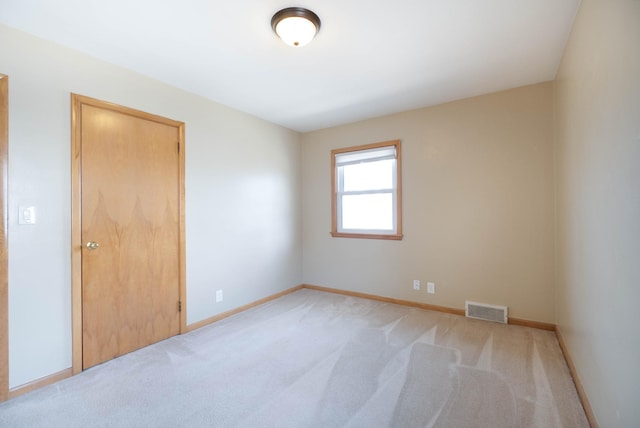 unfurnished room with light carpet, baseboards, and visible vents