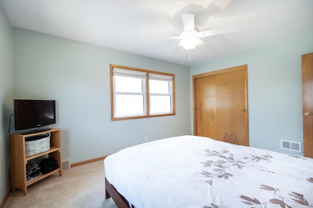 carpeted bedroom featuring baseboards, a ceiling fan, visible vents, and a closet
