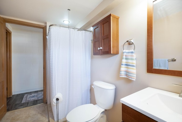 bathroom with toilet, vanity, and a shower with shower curtain