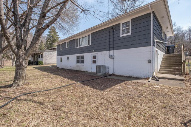 back of house with central AC unit and stairs
