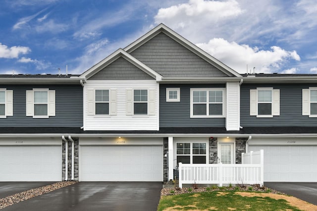 view of front of house featuring a garage, driveway, and stone siding