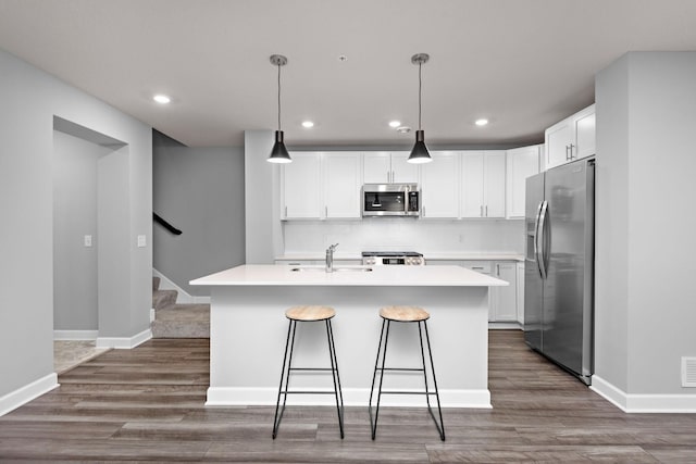 kitchen featuring white cabinets, appliances with stainless steel finishes, and dark wood-style floors