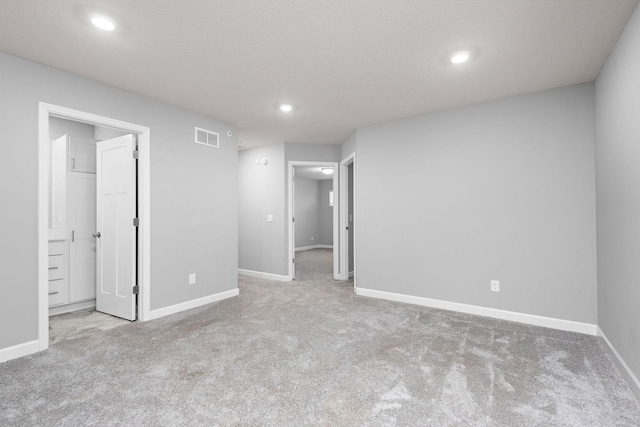 unfurnished bedroom featuring carpet floors, recessed lighting, and visible vents