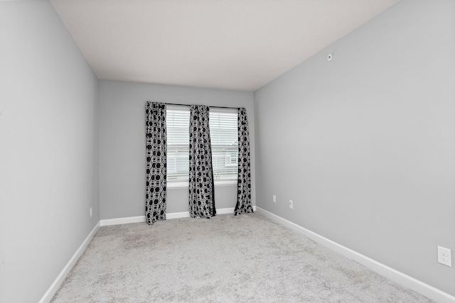 unfurnished room with carpet floors and baseboards