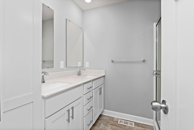 full bath featuring double vanity, baseboards, visible vents, and a sink