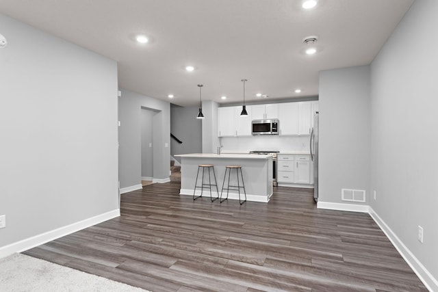 kitchen featuring a center island with sink, stainless steel appliances, recessed lighting, and visible vents