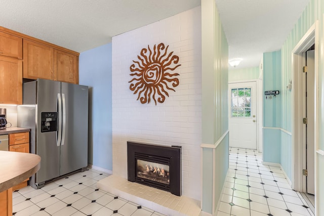 3310 Lake Johanna Blvd, Arden Hills, MN 55112 - kitchen featuring stainless steel refrigerator with ice dispenser, light floors, brown cabinets, and a fireplace