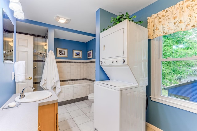 3310 Lake Johanna Blvd, Arden Hills, MN 55112 - bathroom featuring estacked washer and dryer, vanity, tile patterned floors, toilet, and tiled bath