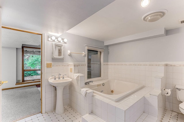 3310 Lake Johanna Blvd, Arden Hills, MN 55112 - bathroom with a whirlpool tub, toilet, tile walls, tile patterned floors, and a sink