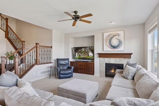 565 Juniper Ct N, Lake Elmo, MN 55042 - living room with stairway, carpet, visible vents, a fireplace, and ceiling fan