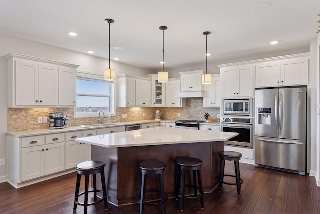 565 Juniper Ct N, Lake Elmo, MN 55042 - kitchen featuring a center island, a sink, stainless steel appliances, dark wood finished floors, and white cabinetry