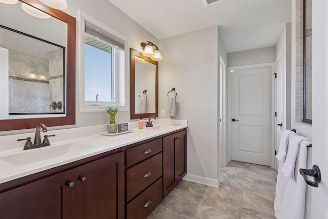 565 Juniper Ct N, Lake Elmo, MN 55042 - full bathroom featuring baseboards, a sink, double vanity, and tiled shower