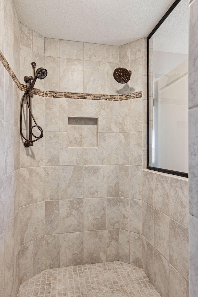 565 Juniper Ct N, Lake Elmo, MN 55042 - bathroom with a textured ceiling and tiled shower