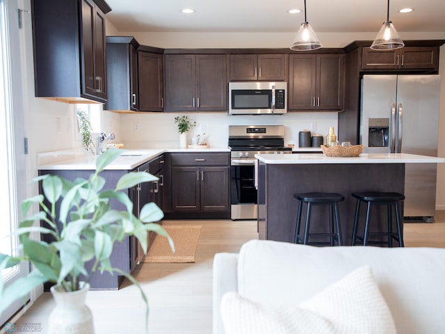 6735 Meadow View Dr S, Fargo, ND 58104 - kitchen featuring light countertops, stainless steel appliances, light wood-type flooring, and dark brown cabinets