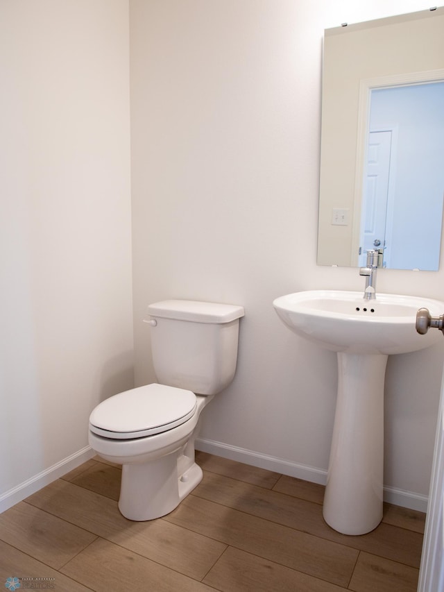 6735 Meadow View Dr S, Fargo, ND 58104 - bathroom with baseboards, a sink, wood finished floors, and toilet