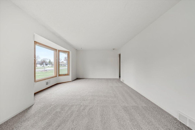 empty room with carpet flooring and visible vents