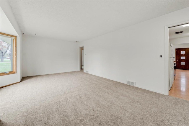 unfurnished room with light carpet and visible vents