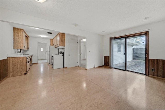 unfurnished living room featuring light wood finished floors and a sink