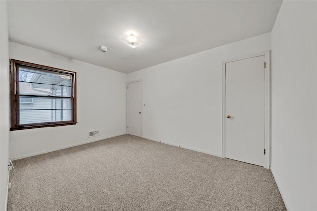 carpeted empty room with baseboards