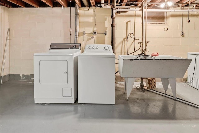 laundry room featuring washing machine and dryer, laundry area, and a sink