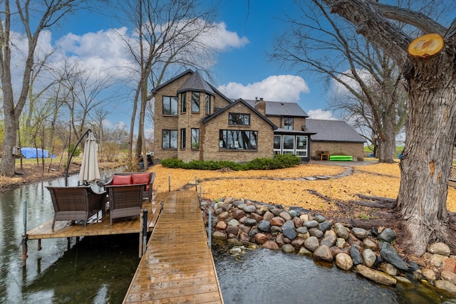 211 Peninsula Rd, Medicine Lake, MN 55441 - rear view of property featuring brick siding, a water view, and a chimney