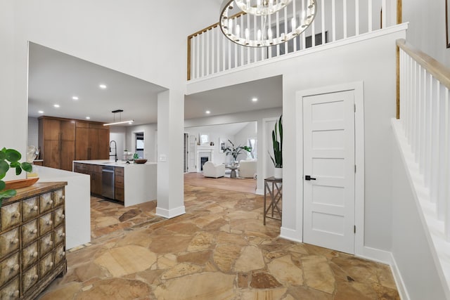 211 Peninsula Rd, Medicine Lake, MN 55441 - entrance foyer with stone flooring, a high ceiling, recessed lighting, stairs, and baseboards