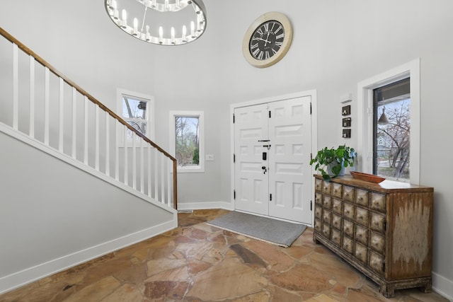 211 Peninsula Rd, Medicine Lake, MN 55441 - entryway with stone flooring, a towering ceiling, healthy amount of natural light, stairway, and baseboards