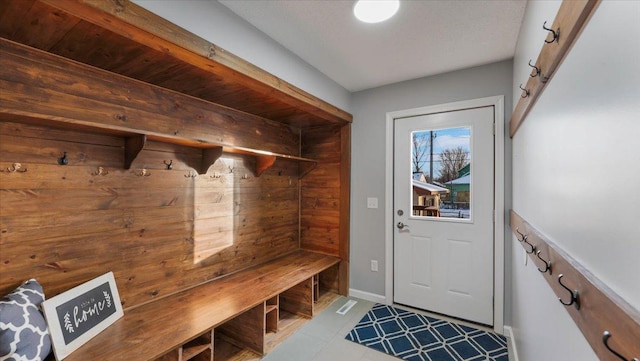 mudroom with baseboards and tile patterned floors
