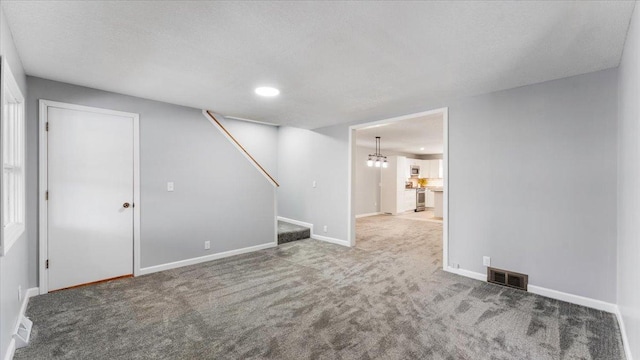 unfurnished living room with recessed lighting, visible vents, carpet floors, baseboards, and stairs