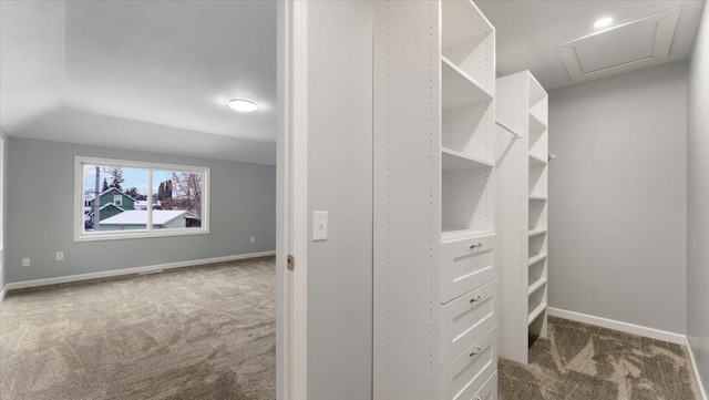 walk in closet with vaulted ceiling and dark colored carpet