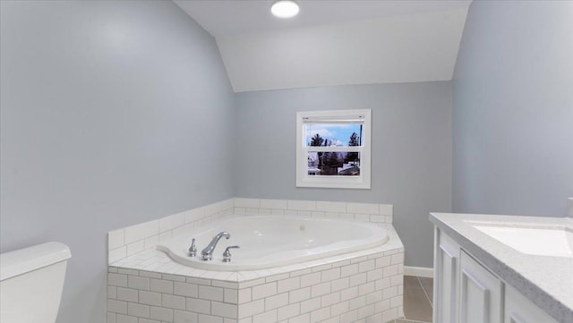 bathroom with lofted ceiling, tile patterned flooring, toilet, vanity, and a garden tub